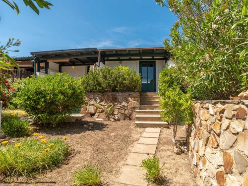 ein Haus mit einer Steinmauer und einer Treppe, die dorthin führt in der Unterkunft Holiday Home Sa Casitta by Interhome in Stintino