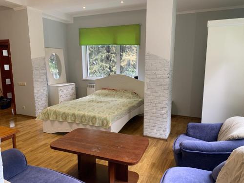 1 dormitorio con 1 cama, mesa y sillas en Апартаменты с парковкой и мангалом Kirova 10 А, en Yalta