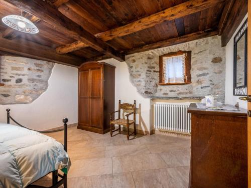 a bedroom with a bed and a stone wall at Apartment Les Cors-1 by Interhome in Fenis