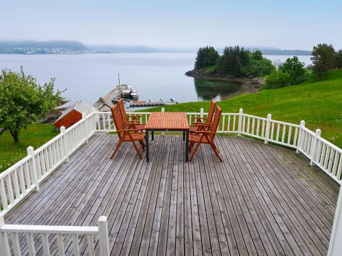 une table et des chaises sur une terrasse avec vue sur l'eau dans l'établissement Holiday Home Havsblikk - FJS531 by Interhome, à England