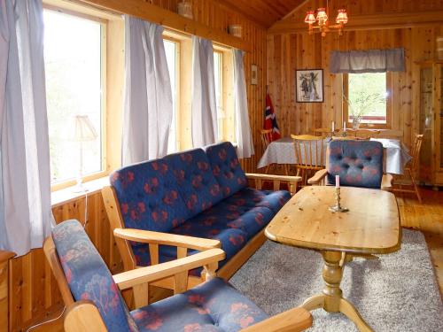 a living room with a couch and a table at Chalet Revebjella - FJS086 by Interhome in Viksdalen