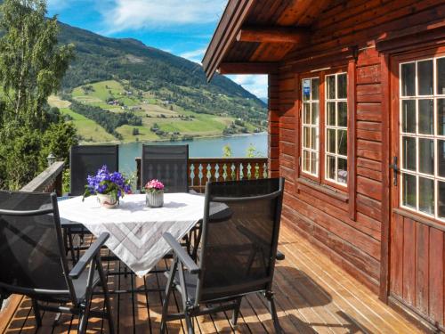 a table on a deck with a view of a lake at Chalet Fjordblick I - FJS311 by Interhome in Olden