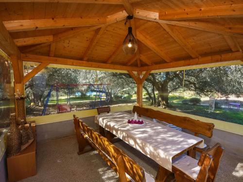 - un pavillon en bois avec une table, des chaises et une aire de jeux dans l'établissement Holiday Home Franka by Interhome, à Kraj
