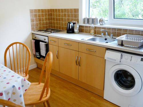 a kitchen with a sink and a washing machine at Holiday Home Alan's House by Interhome in Staffin