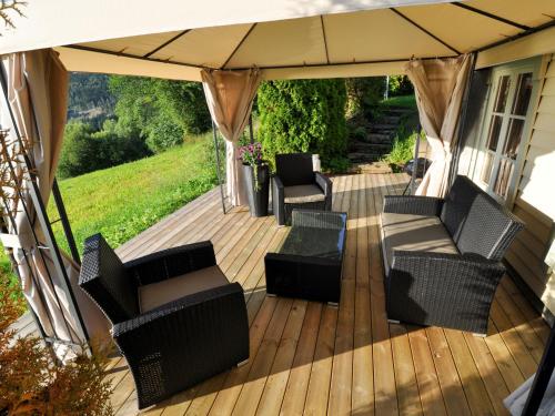 a wooden deck with chairs and an umbrella at Chalet Nystova - FJS250 by Interhome in Innvik