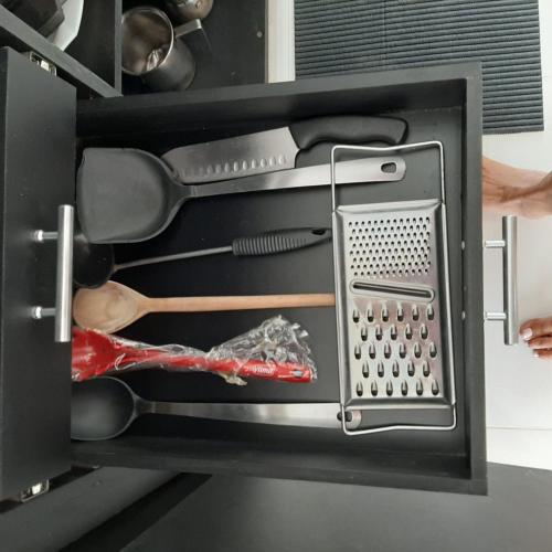 a drawer filled with cooking utensils in a cabinet at Casa Vitória em barra de jacuipe in Campos