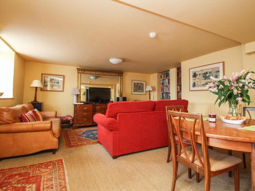 a living room with a red couch and a table at The Slipway in Penzance