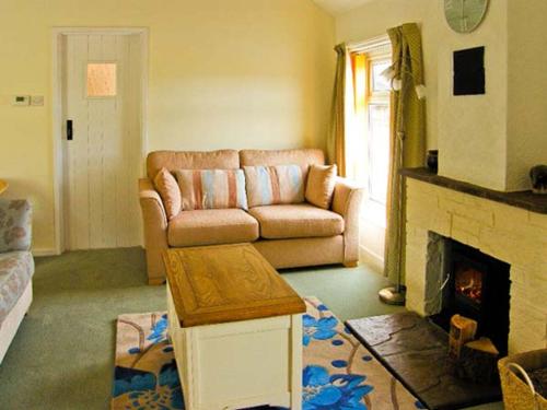 a living room with a couch and a fireplace at Waterloo Cottage Annexe in Ruswarp