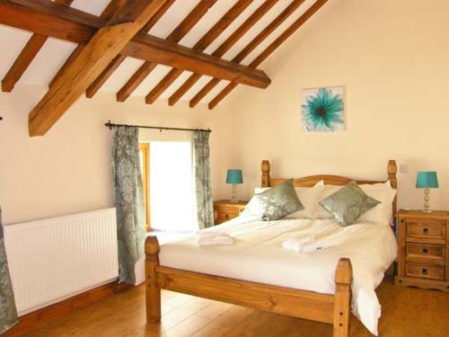 a bedroom with a large bed and a window at Stabal-y-Gwedd in Llanddulas