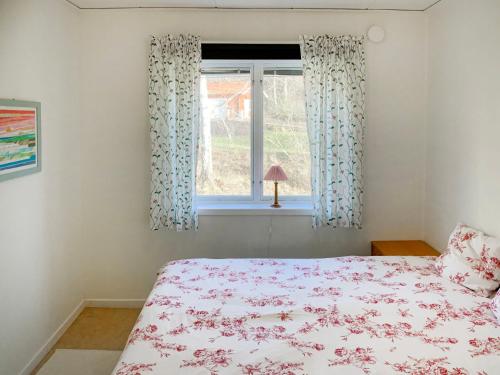 1 dormitorio con cama y ventana en Chalet Lindby Pärlan - STH150 by Interhome en Adelsö