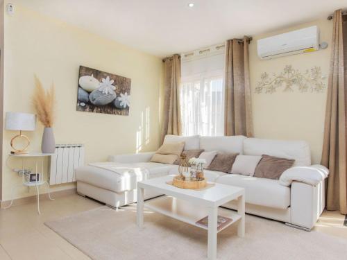 a living room with a white couch and a table at Holiday Home Emballia by Interhome in Caulés