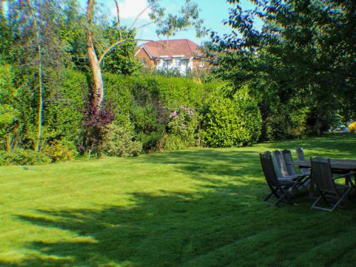 a yard with two chairs and a table in the grass at Holiday Home Goudhurst by Interhome in Marden