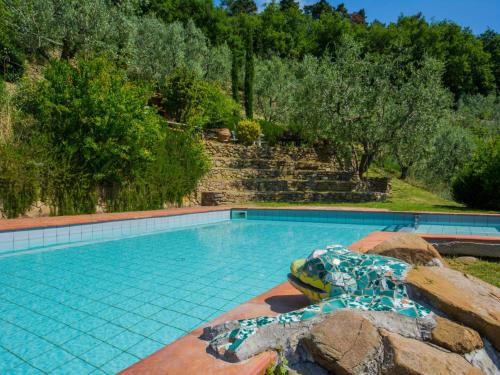 een groot zwembad met een rots en bomen bij Apartment La Baghera by Interhome in Fornello