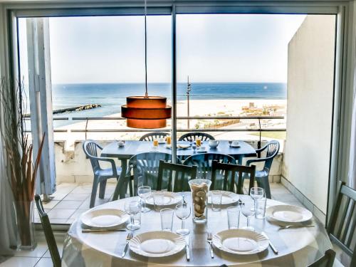 a dining room with a table and a view of the ocean at Apartment Grand Pavois-2 by Interhome in Mimizan-Plage