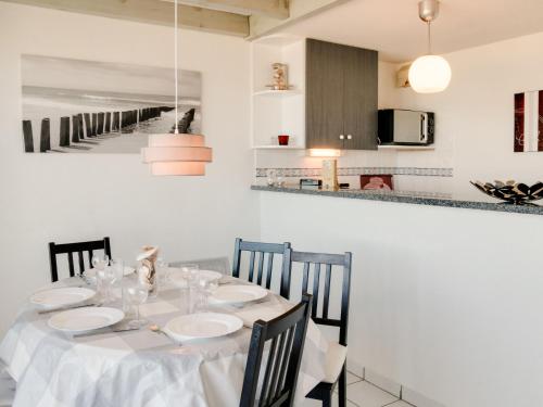 a dining room with a table and a kitchen at Apartment Grand Pavois-2 by Interhome in Mimizan-Plage