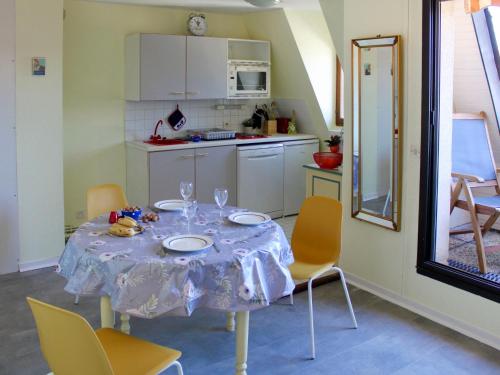 a kitchen with a table with chairs and a tablecloth on it at Apartment Le Plazza by Interhome in Deauville