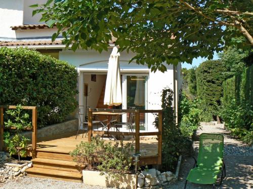 ヴィルヌーヴ・レ・ザヴィニョンにあるHoliday Home L'Oasis provencale - AVI120 by Interhomeの木製デッキ(テーブル、傘付)