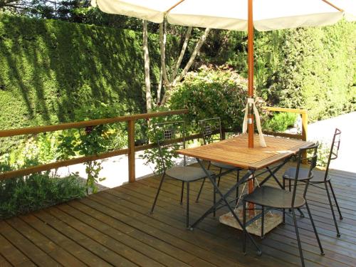 ヴィルヌーヴ・レ・ザヴィニョンにあるHoliday Home L'Oasis provencale - AVI120 by Interhomeのデッキ(パラソル付)にテーブルと椅子