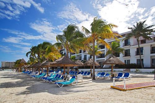 a group of chairs and umbrellas on a beach at The Royal Cancun All Suites Resort in Cancún
