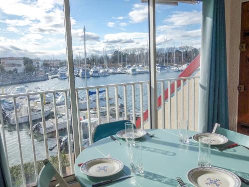 サン・シプリアン・プラージュにあるApartment Marinas du Ponant by Interhomeの港の景色を望むバルコニー(ワイングラス付きのテーブル付)