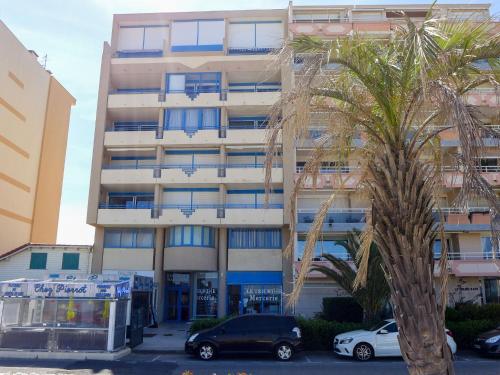 un bâtiment avec un palmier devant dans l'établissement Apartment Marianne by Interhome, à Canet