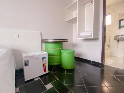 a kitchen with two green trash cans and a refrigerator at GUINZA in Balneário Camboriú