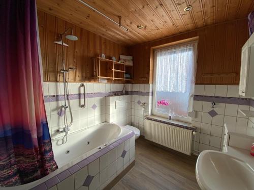 a bathroom with a tub and a sink at Ferienwohnung "Bine" in Lübeck