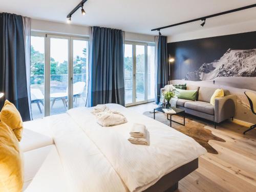a bedroom with a large bed and a couch at Apartment Mariandl am Meer-1 by Interhome in Binz