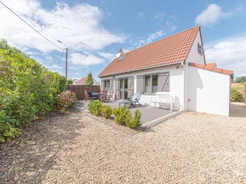 a white cottage with a patio in front of it at Holiday Home New Village Park-3 by Interhome in Bredene