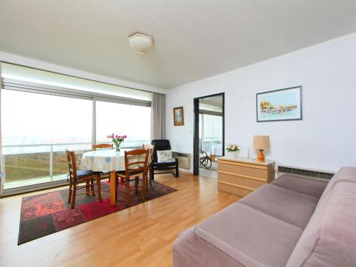 een woonkamer met een bank en een tafel met stoelen bij Apartment Residentie Astrid-8 by Interhome in Bredene