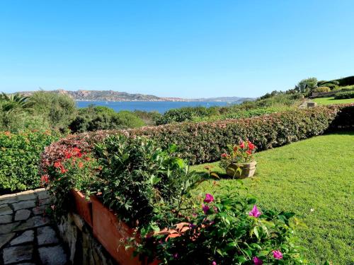 ogród z kwiatami na ścianie z jeziorem w obiekcie Holiday Home Nicoletta by Interhome w mieście Palau