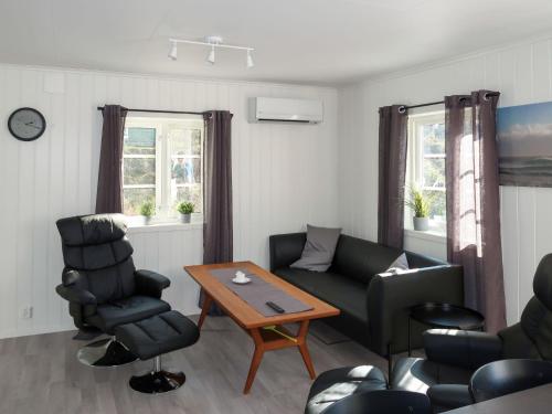 sala de estar con sofá, mesa y sillas en Holiday Home Nesholmen - FJS127 by Interhome, en Leirvik