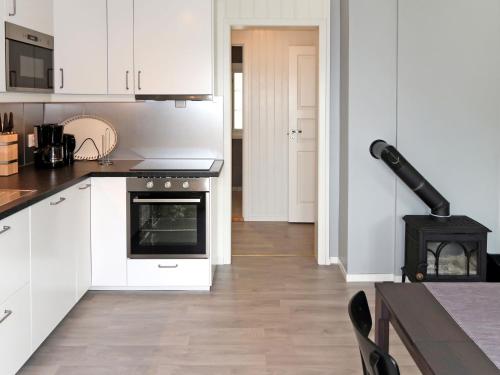 cocina con armarios blancos y fogones en Holiday Home Nesholmen - FJS127 by Interhome, en Leirvik