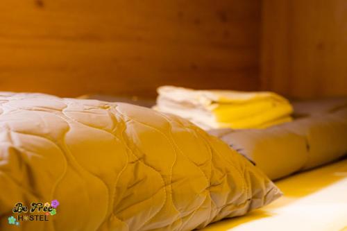 a yellow comforter laying on top of a bed at BeFree Hostel - Self-Service in Vienna