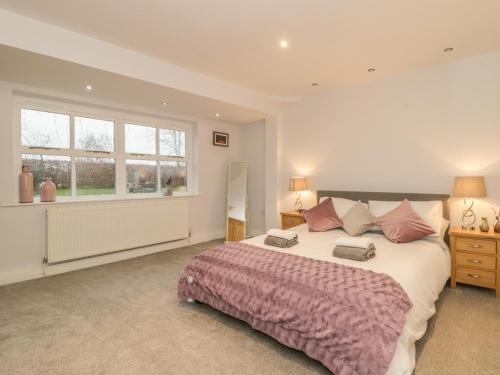 a bedroom with a large bed and a window at Hare Cottage in Market Rasen