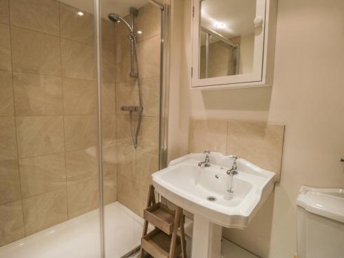a bathroom with a sink and a shower at Hare Cottage in Market Rasen