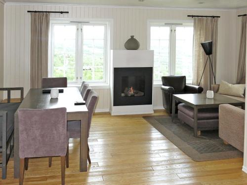 ein Wohnzimmer mit einem Tisch und einem Kamin in der Unterkunft Apartment Havsdalsgrenda - HLD103 by Interhome in Geilo