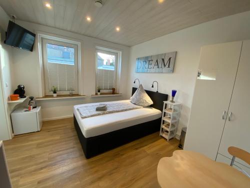 um quarto com uma cama com uma placa de sonho na parede em Pensionszimmer Melina em Lübeck
