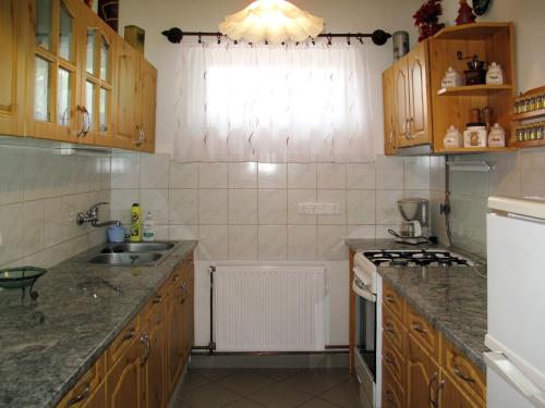 una pequeña cocina con armarios de madera y fregadero en Holiday Home Brigi - SZA113 by Interhome, en Balatonszárszó