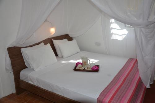 uma cama com um ursinho de peluche e flores em Kokogrove Chalets em Anse Royale