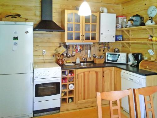 a kitchen with wooden cabinets and a white refrigerator at Holiday Home Hajnal - FOD146 by Interhome in Fonyód