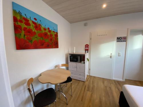 a small room with a small table and a kitchen at Pensionszimmer Melina in Lübeck