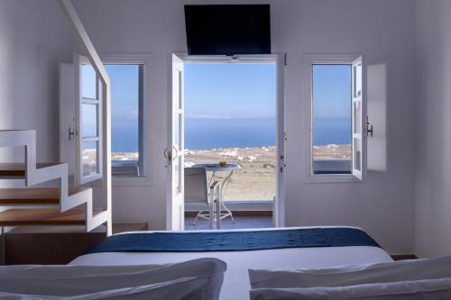 a bedroom with a bed and a view of the ocean at Muses Cycladic Suites in Oia