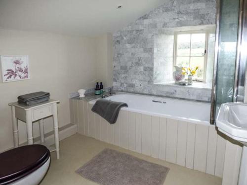 uma casa de banho com uma banheira, um WC e um lavatório. em Rose Cottage em Monmouth