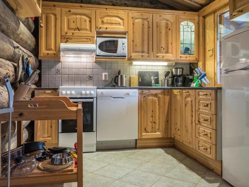 禹拉斯加威的住宿－樂森瑪耶B度假屋，厨房配有木制橱柜和白色冰箱。