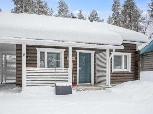 ユッラスヤルヴィにあるHoliday Home Ylläsjuolukka b by Interhomeの雪の青い扉のある木造家屋