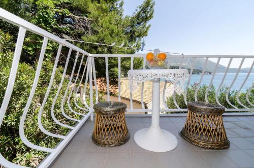 a table and two wicker chairs on a balcony at Guest House Daniela in Mlini