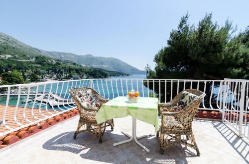 a table and chairs on a balcony with a view of the water at Guest House Daniela in Mlini