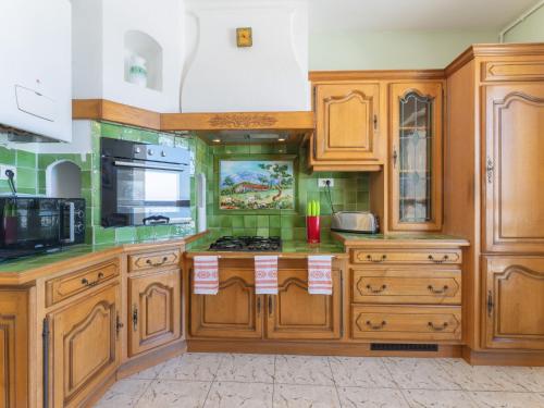 cocina con armarios de madera y horno con fogones en Apartment La Maison de Protis - MSE100 by Interhome en Marsella