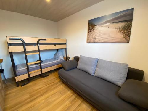 ein Wohnzimmer mit einem Sofa und Etagenbetten in der Unterkunft Pensionszimmer Hannes in Lübeck